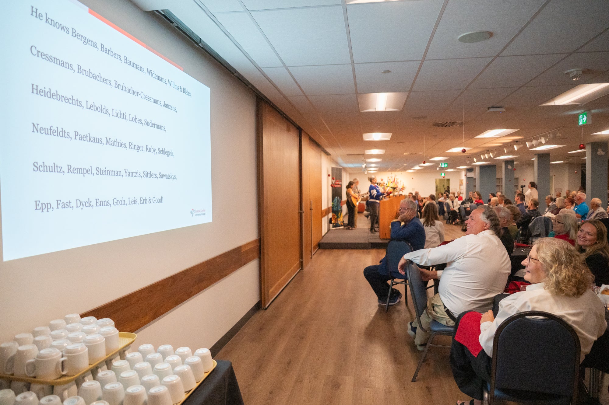 Dining room with guests at fred's retirement. Singing a song together.