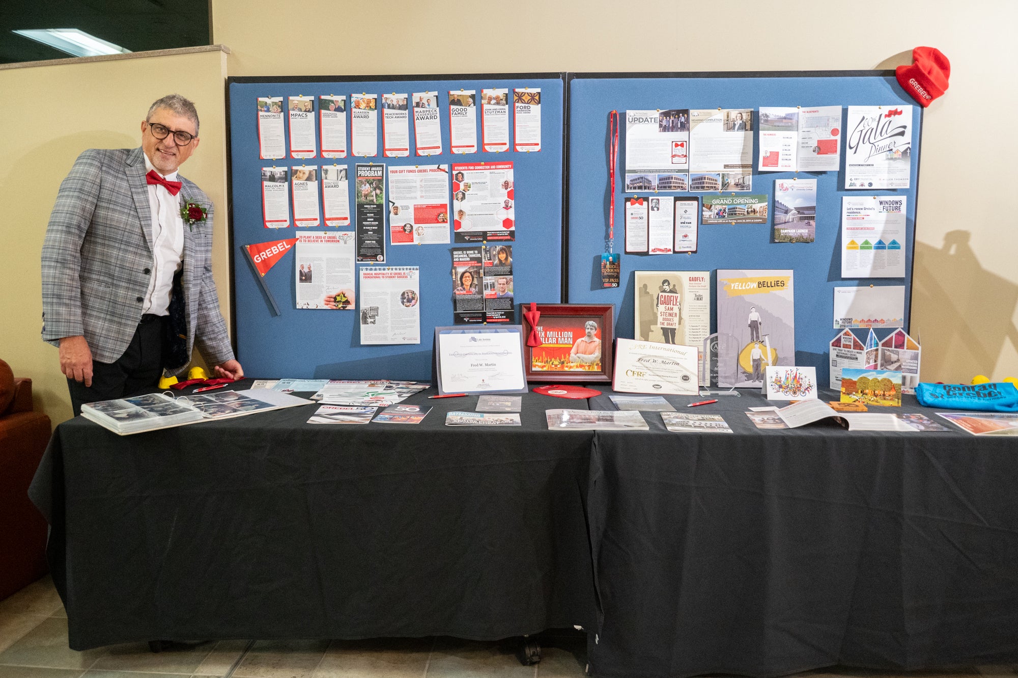 Fred stands next to a table display with work he's helped complete at Grebel.