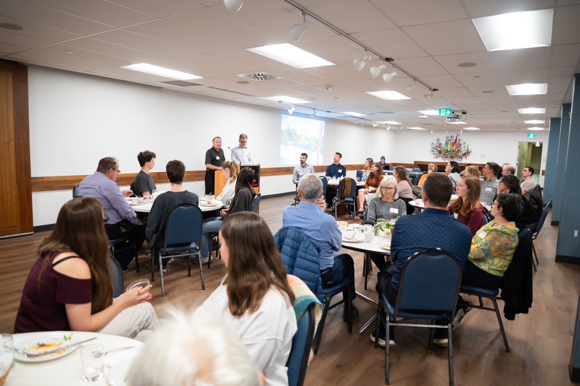 Peter Hart gives a speech at the podium, in the Grebel dining room