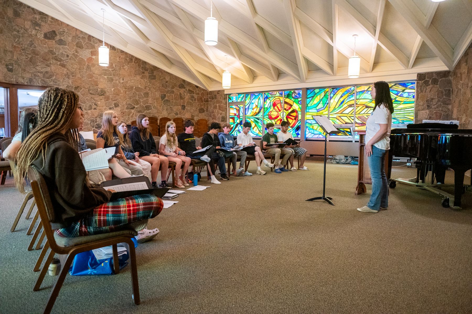 A group of music camp students sit in the Grebel chapel