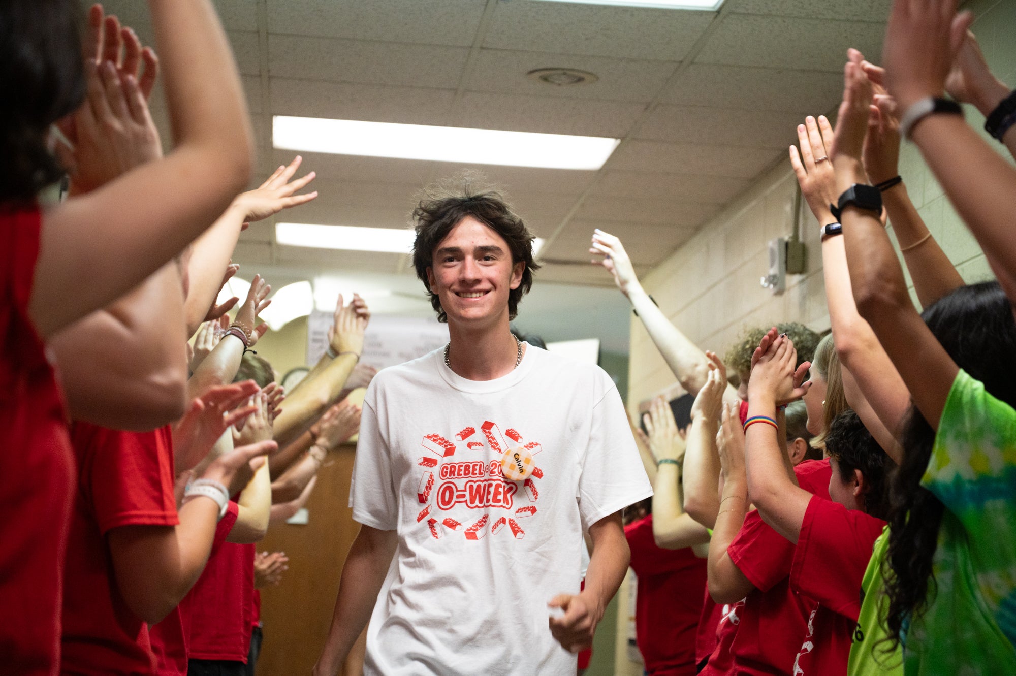 a student walks down a line of cheering student leaders
