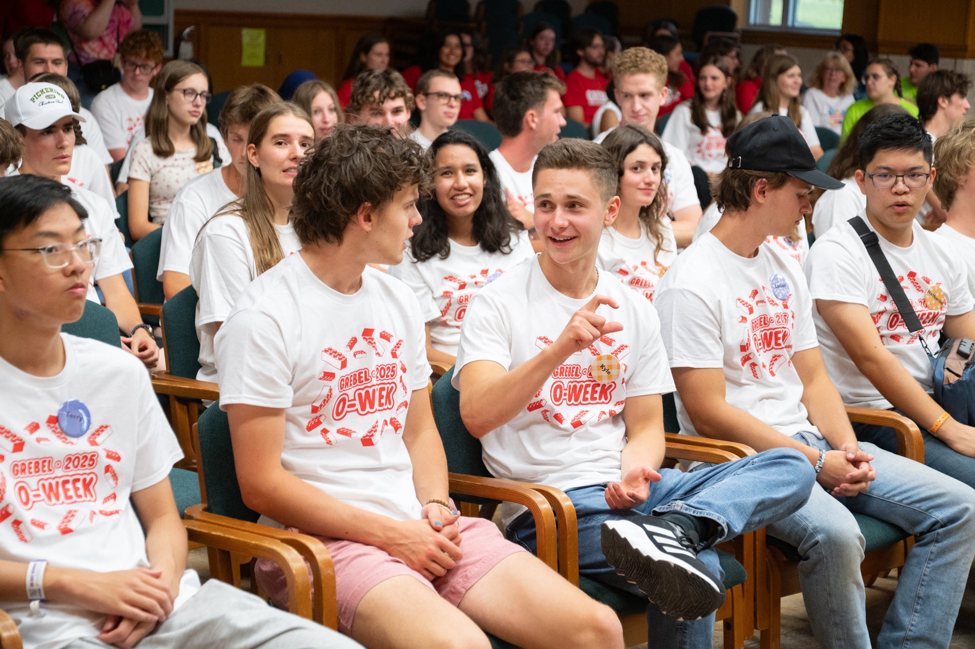 two students speak while sitting in the great hall