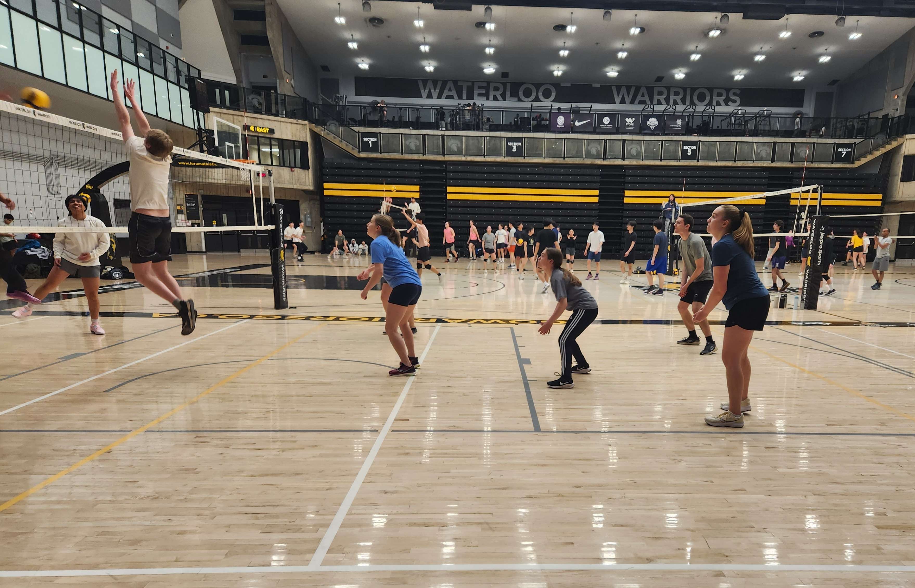 Students playing volleyball indoors