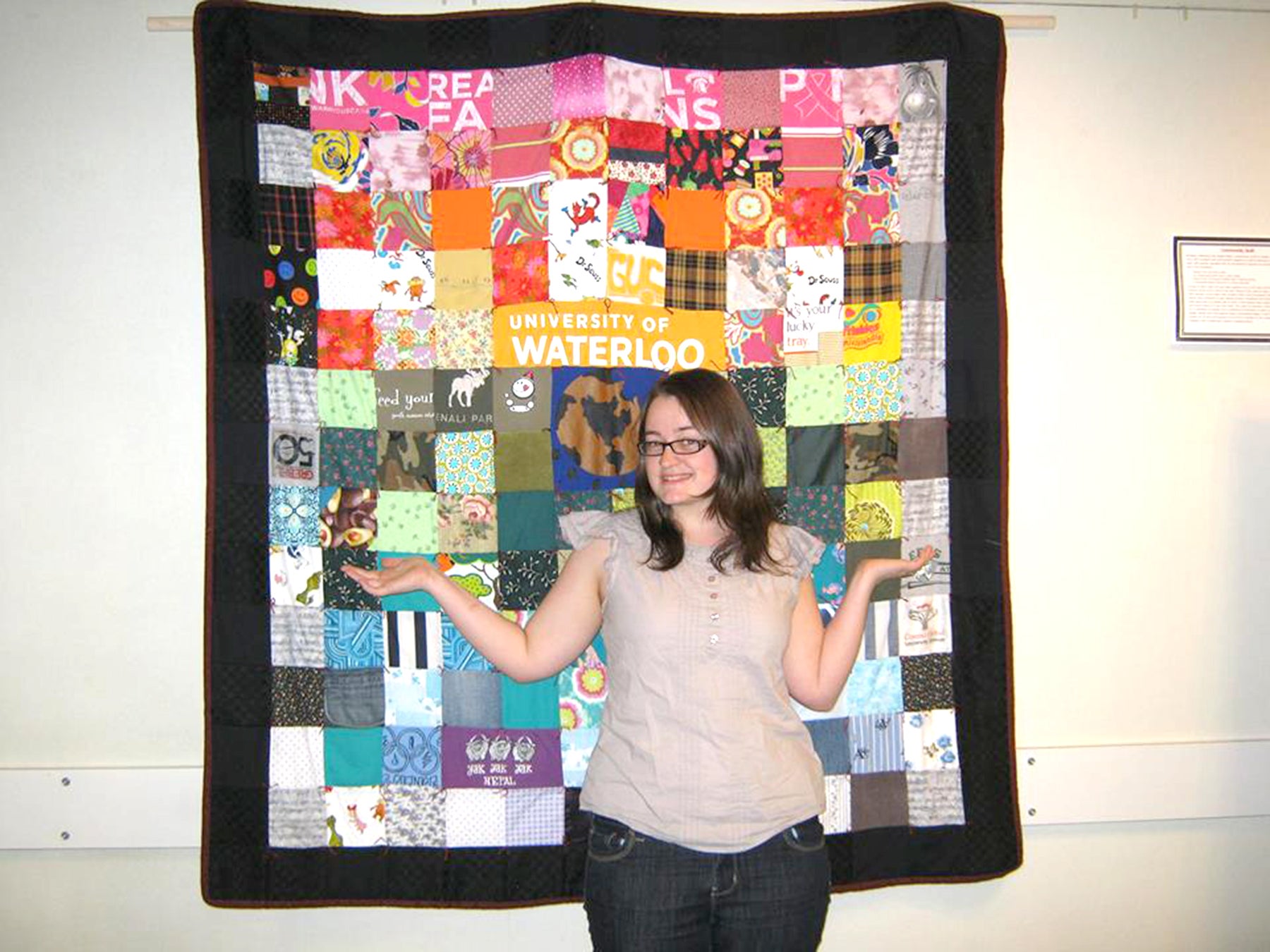 student standing in front of quilt