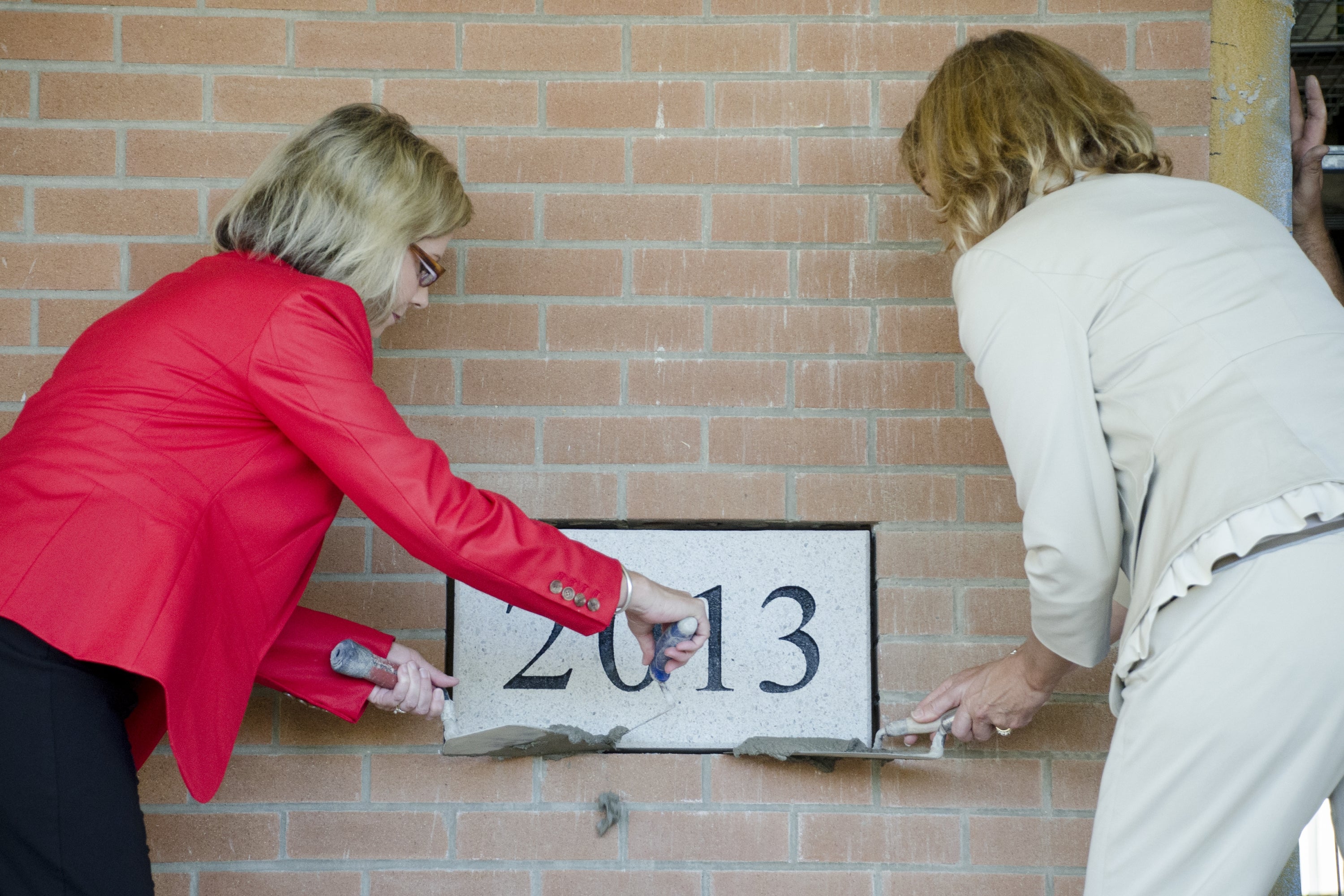 placing the date stone into the wall