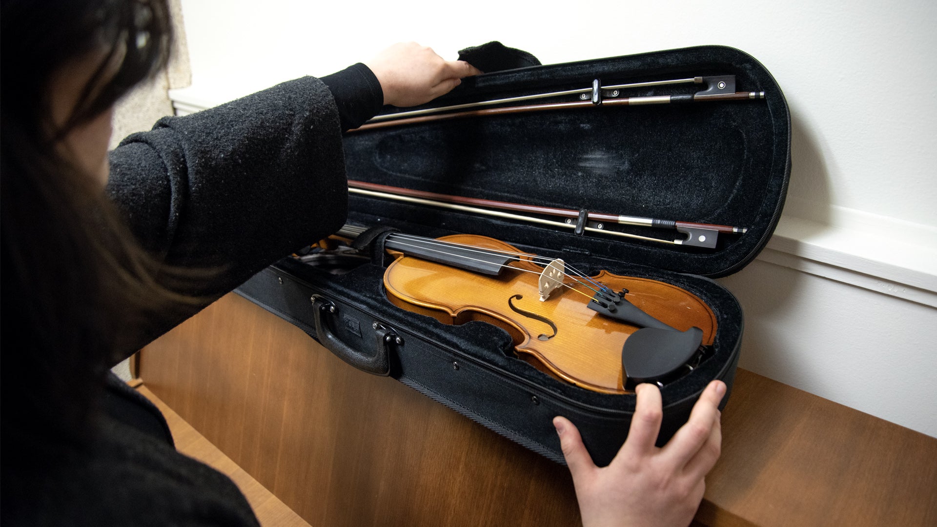 Darley Dau opening her violin case. 
