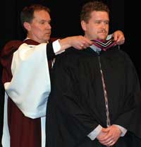 Jim hooding Andrew in the convocation
