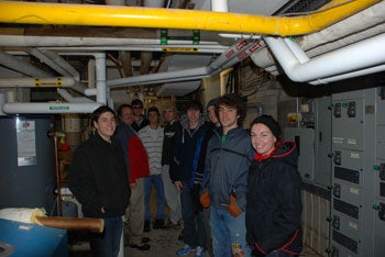 A group photo of the Solar Grebel under the pipes used for the solar panels.