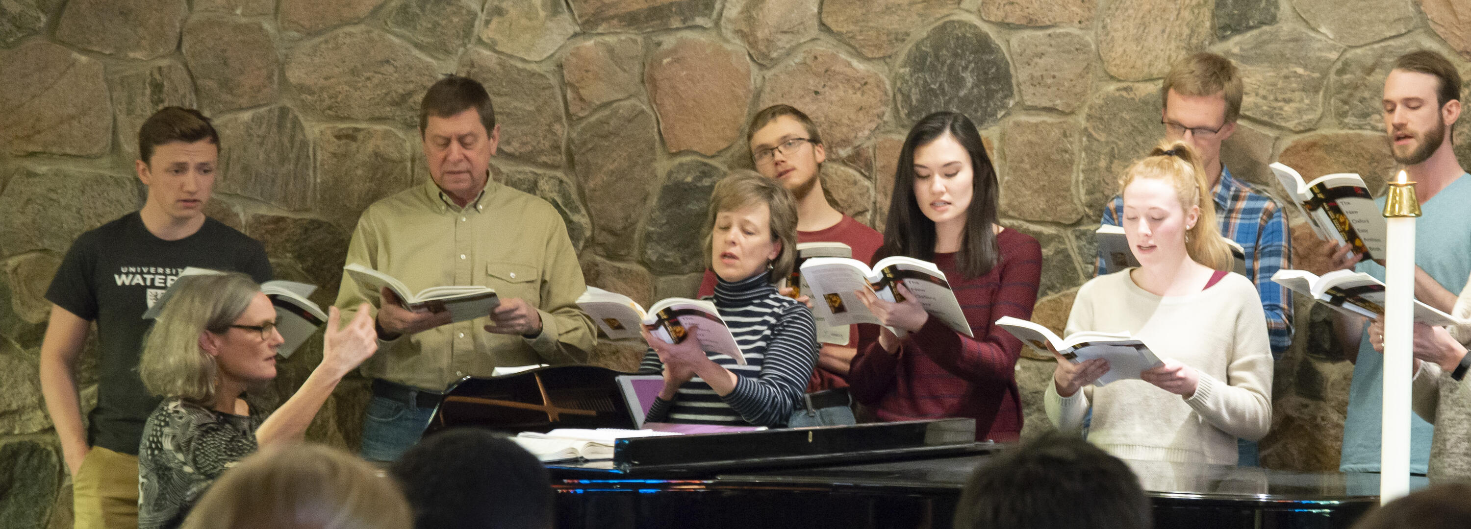 catherine plays a piano in the grebel chapel with a student choir