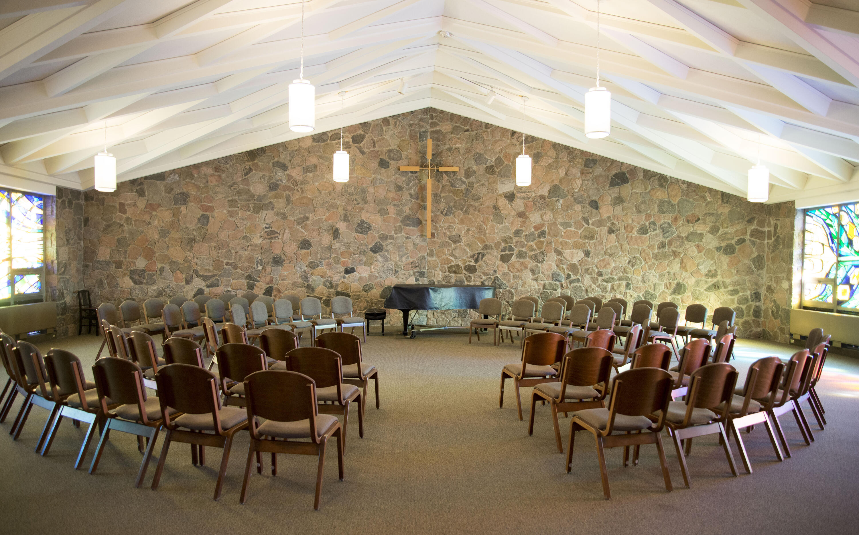 Chapel with chairs, stained glass, and grand piano