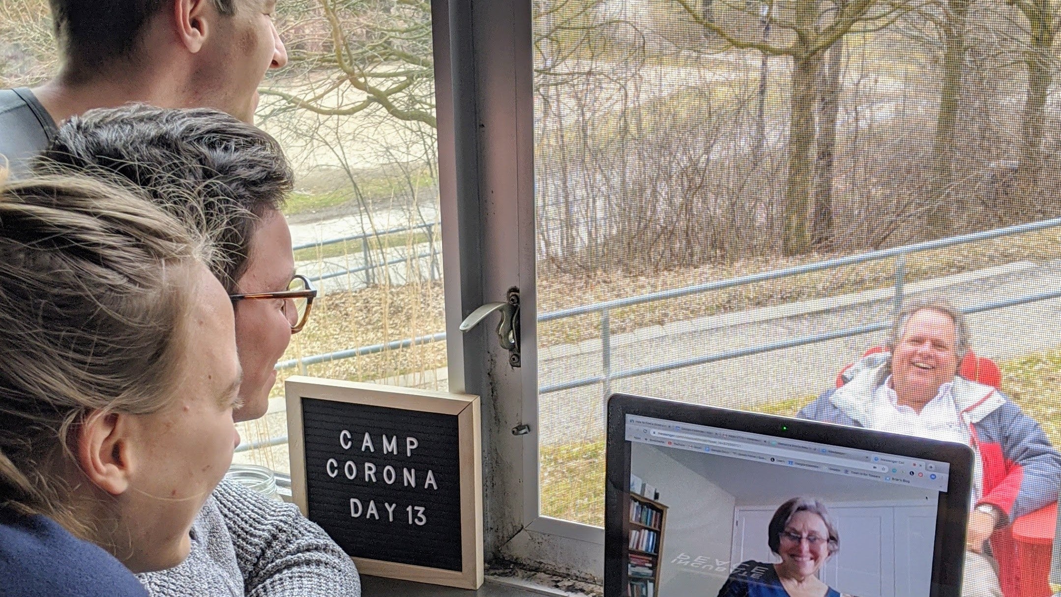 Apartment residents visit with staff through window and video chat