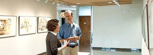 Professor talking with colleague in the Grebel Gallery