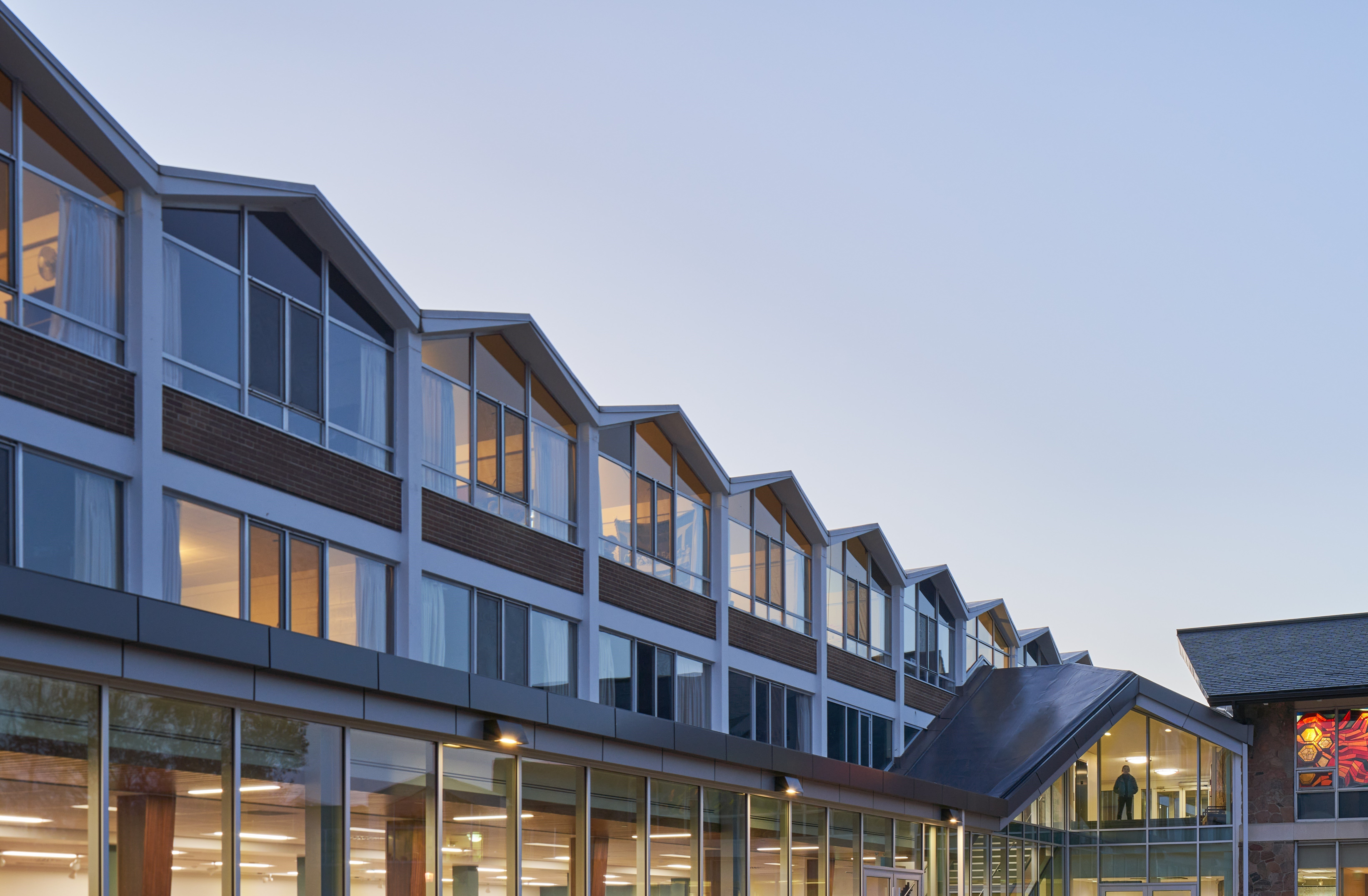 A view of the Grebel residence building at dusk, featuring its iconic peaked rooves.