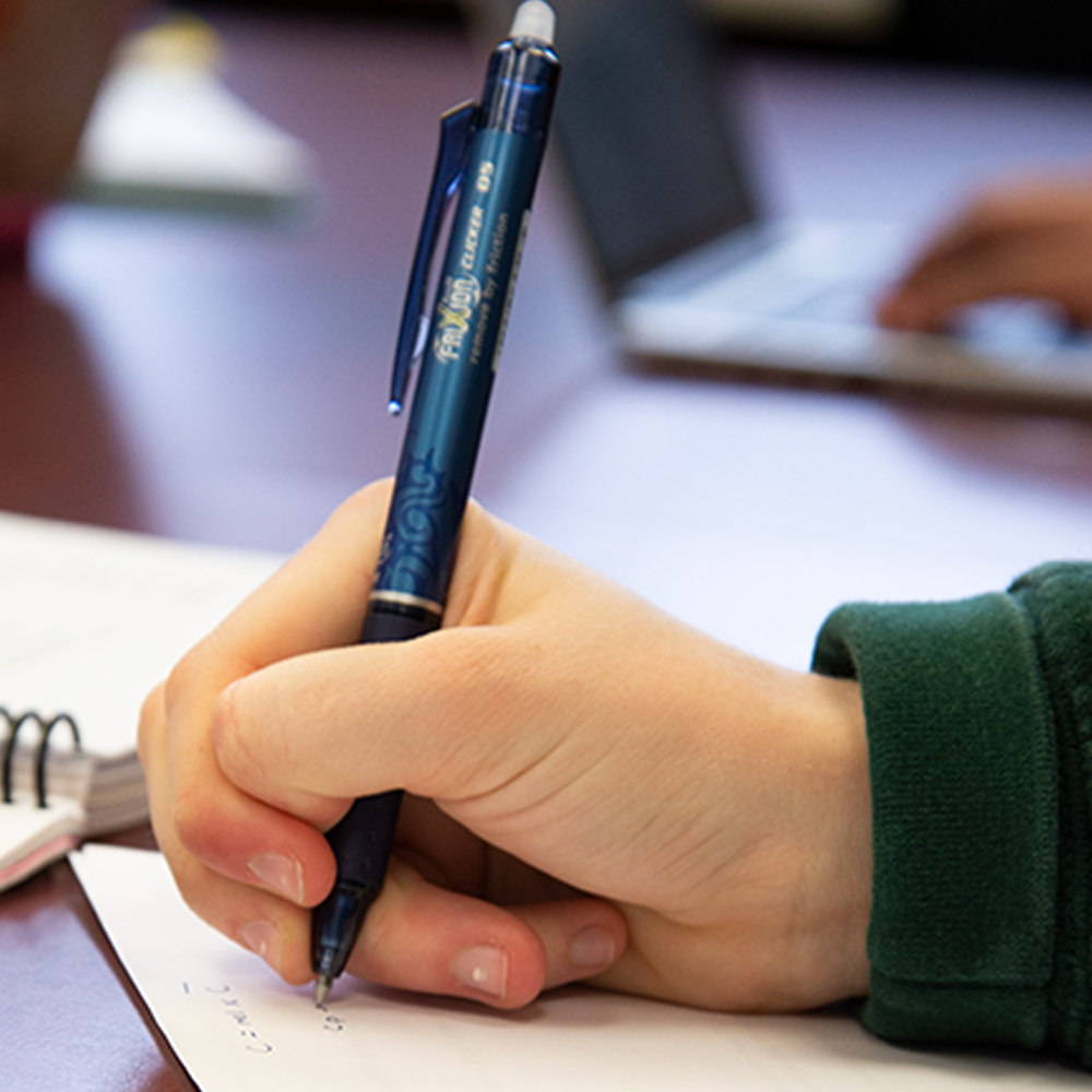 Student hand writing with pen