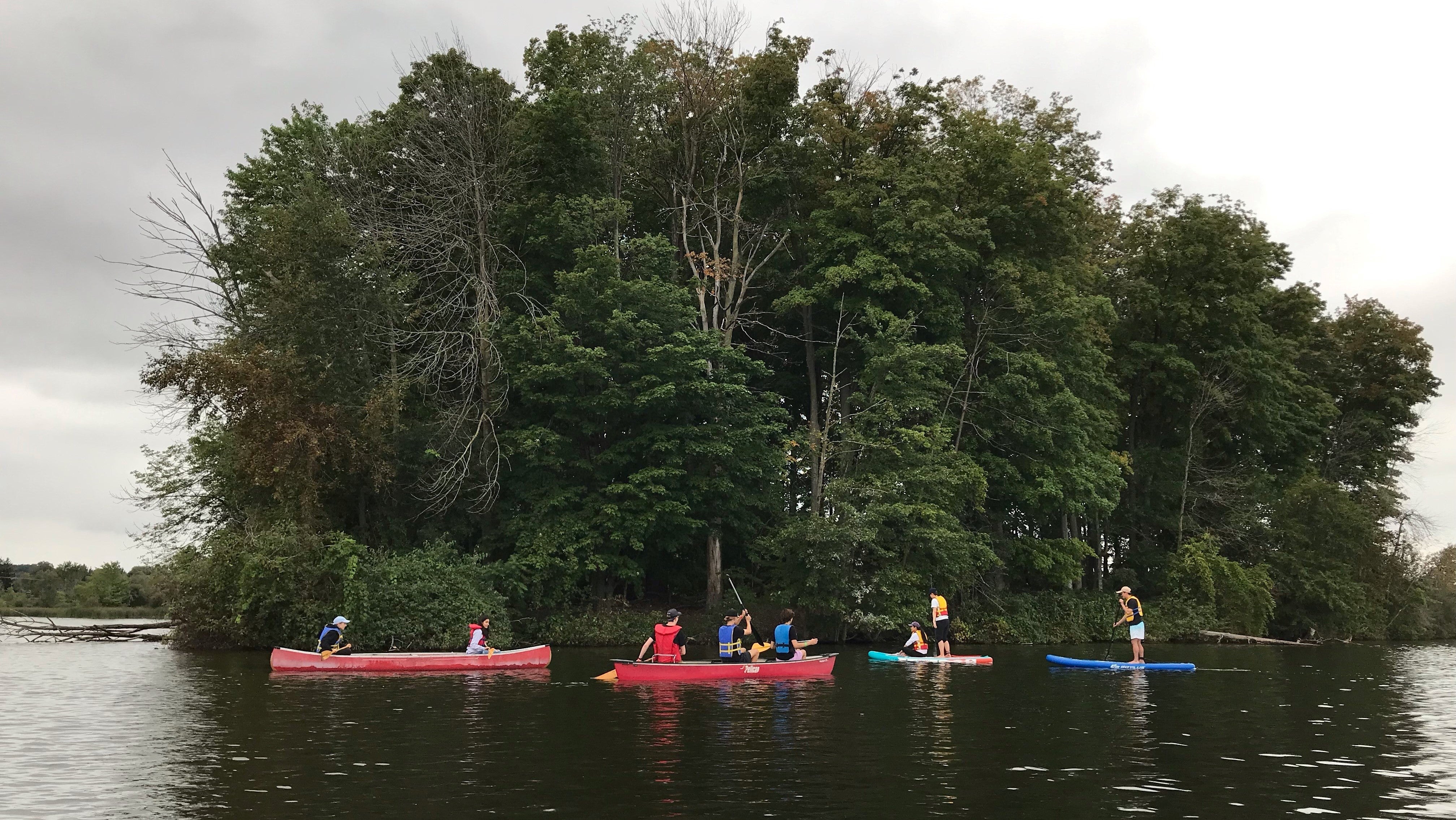 Students canoeing on lake. 