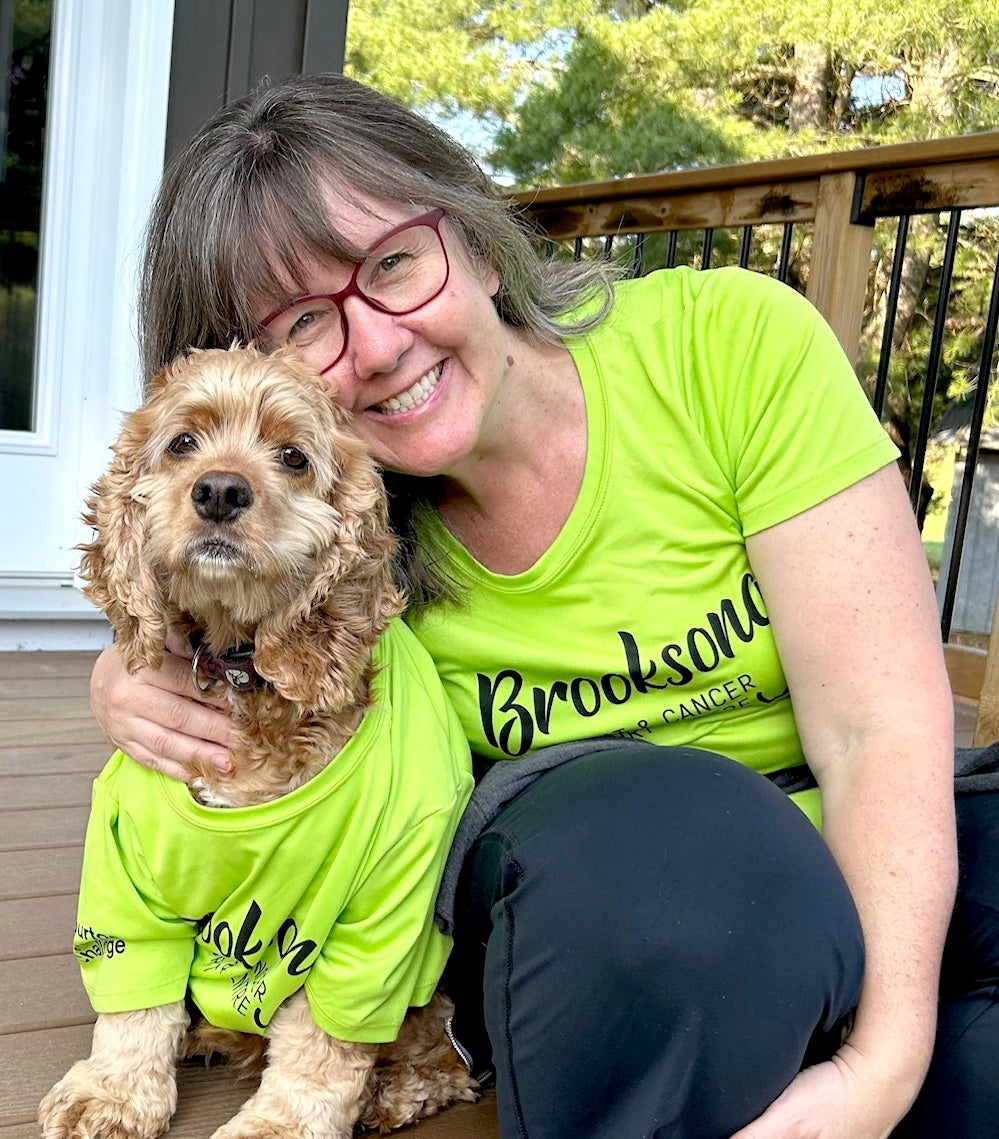 Barb Smith-Morrison with a dog, both wearing Brooksong tshirts