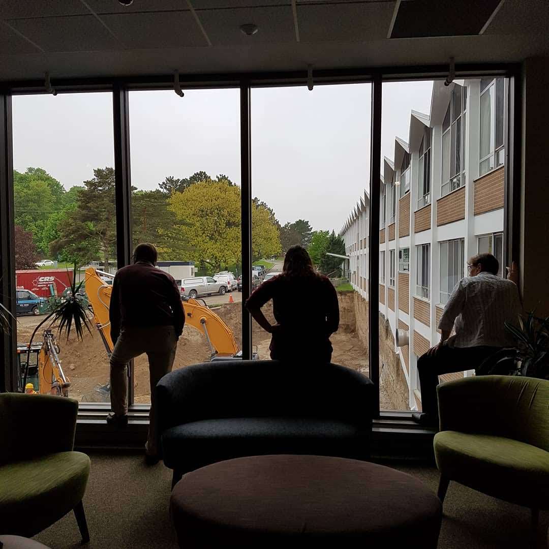 Staff watch construction progress from the library windows