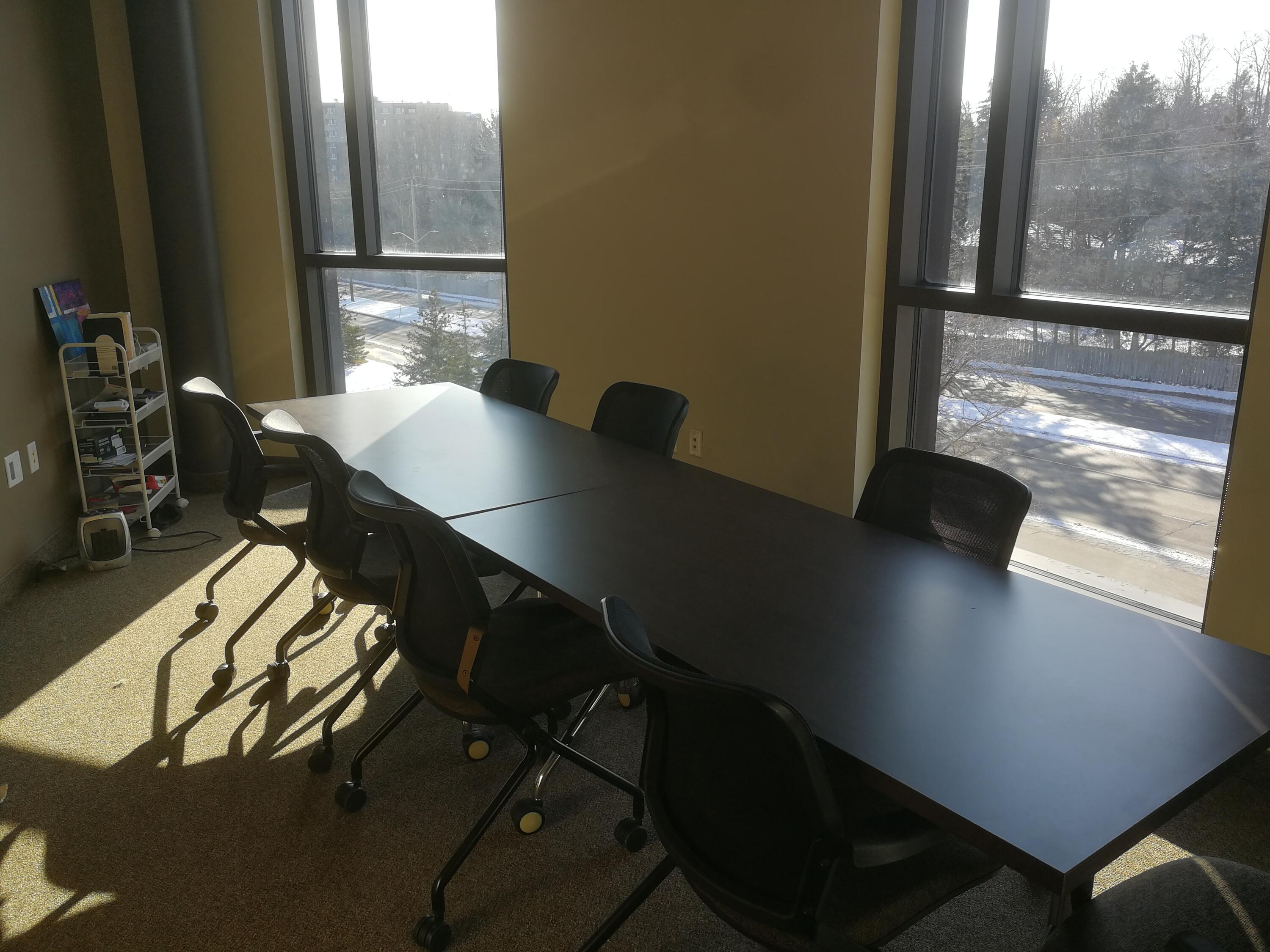 Small meeting room with a long table and 8 chairs