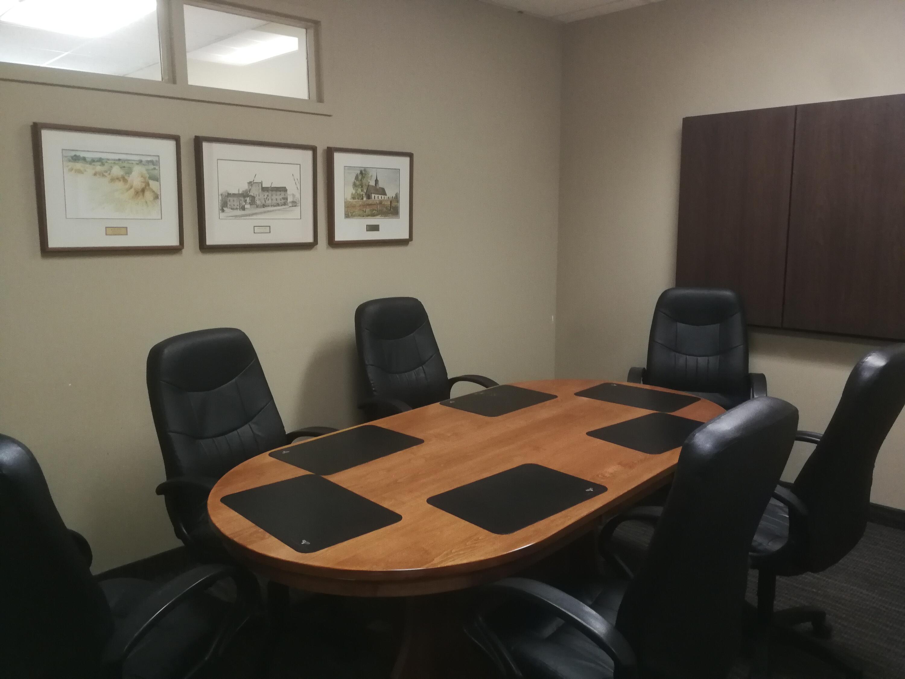 Small meeting room with wooden table and 6 chairs