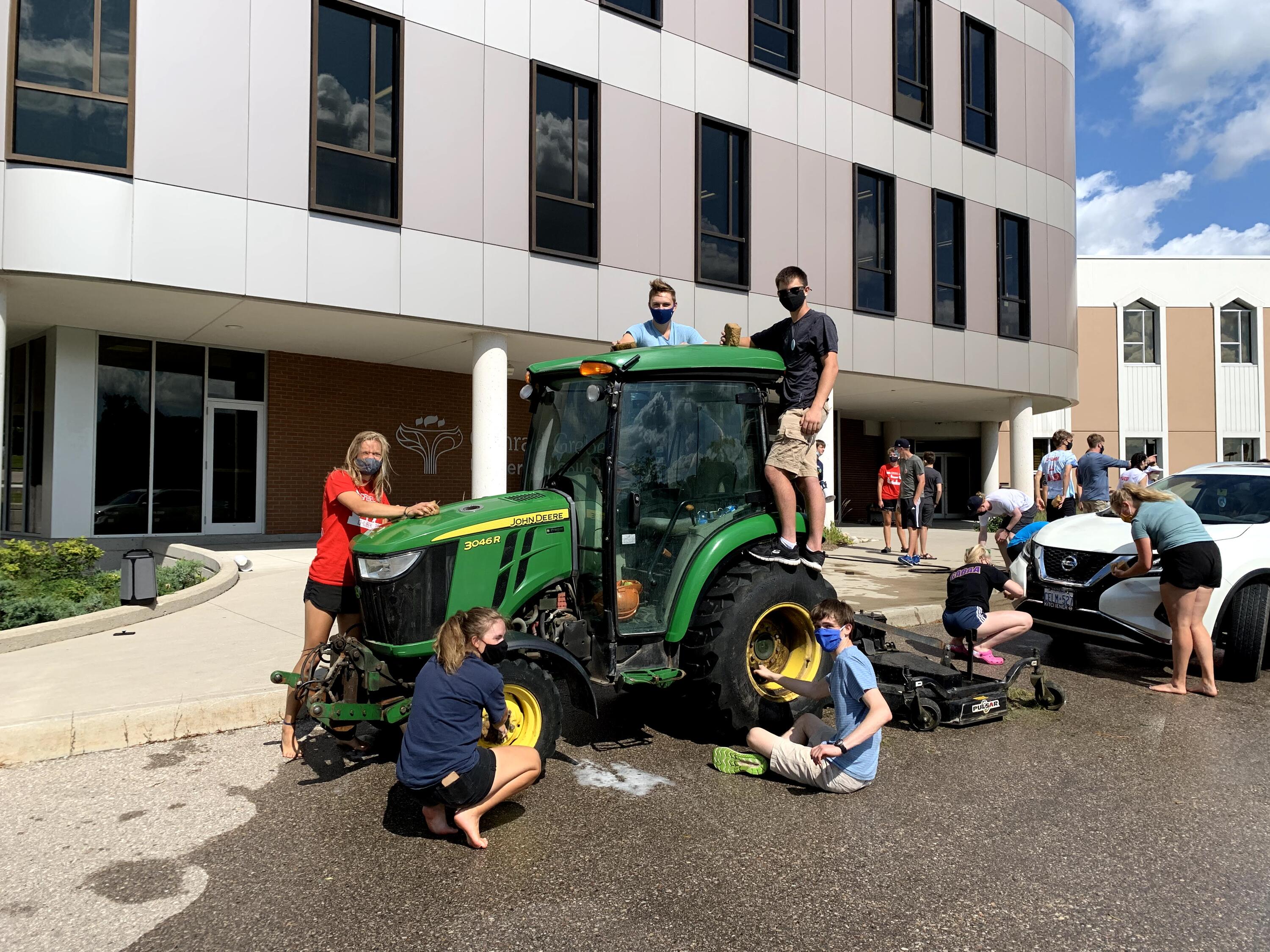 students posing with a tractor 