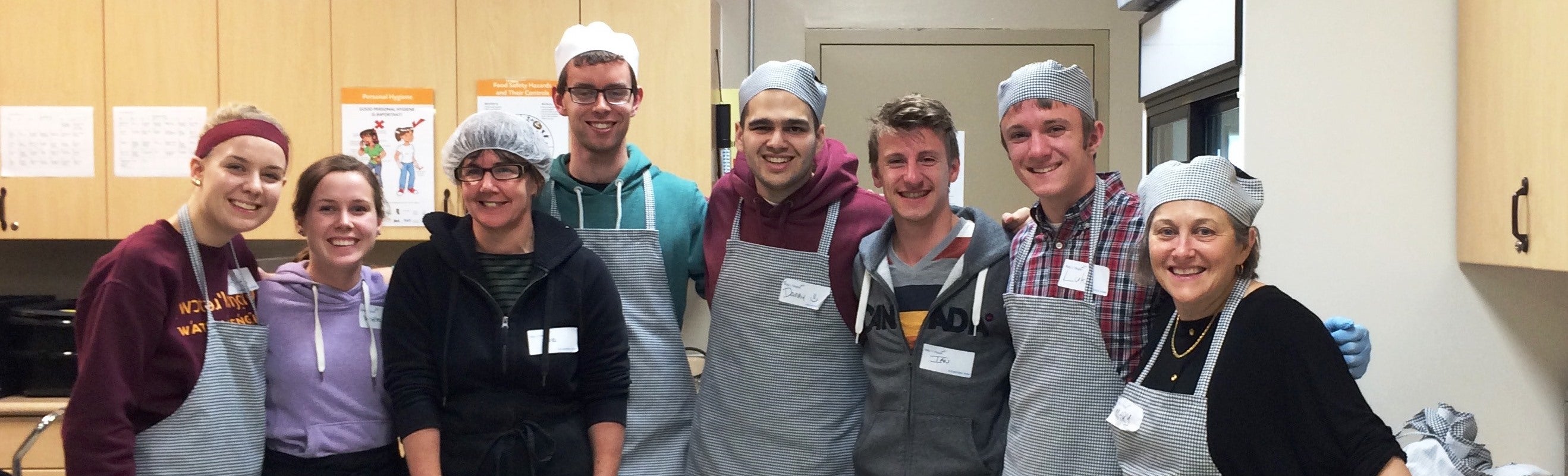 Grebel students and staff: Justine, Whitley, Sue, Christian, Danny, Ian, Luke, and Mary take a break from serving a meal at Ray of Hope.