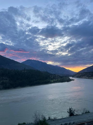 A scenic sunset over mountains and a river