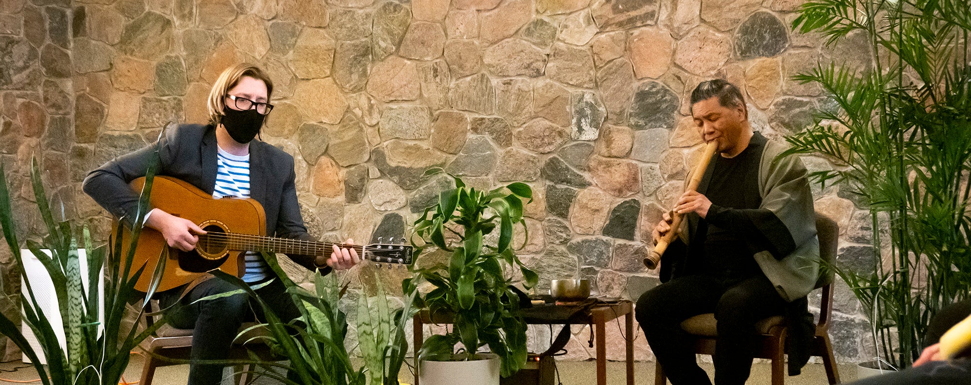 Two people playing guitar and flute