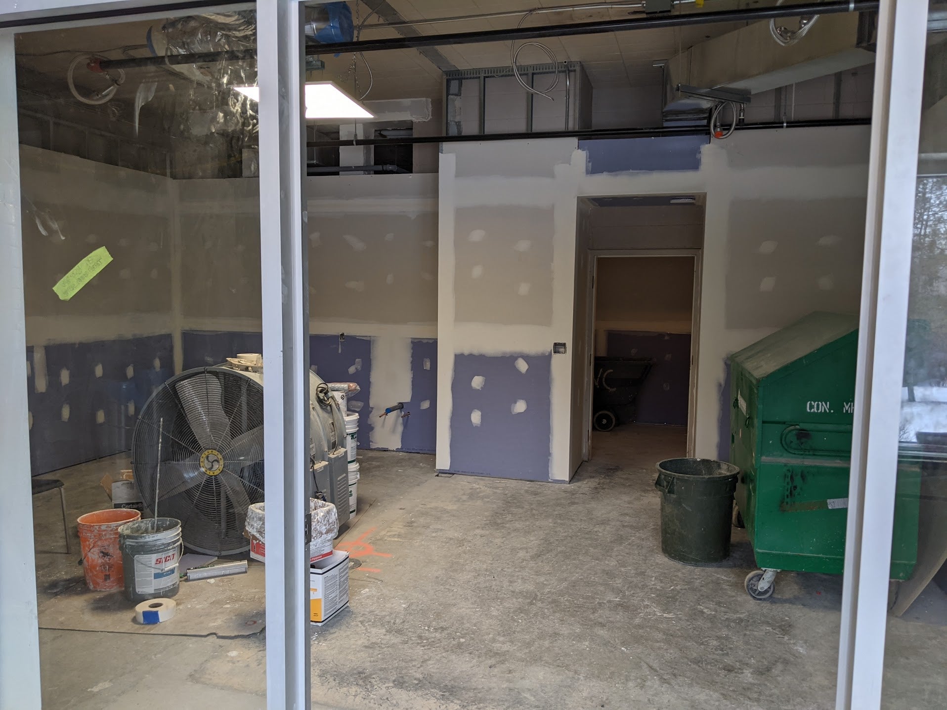 a look inside a new room under construction, with a glass entrance. 