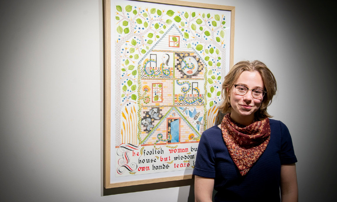 Meg Harder standing beside one of her artworks