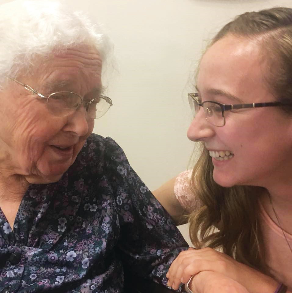Young woman talking and laughing with elderly woman