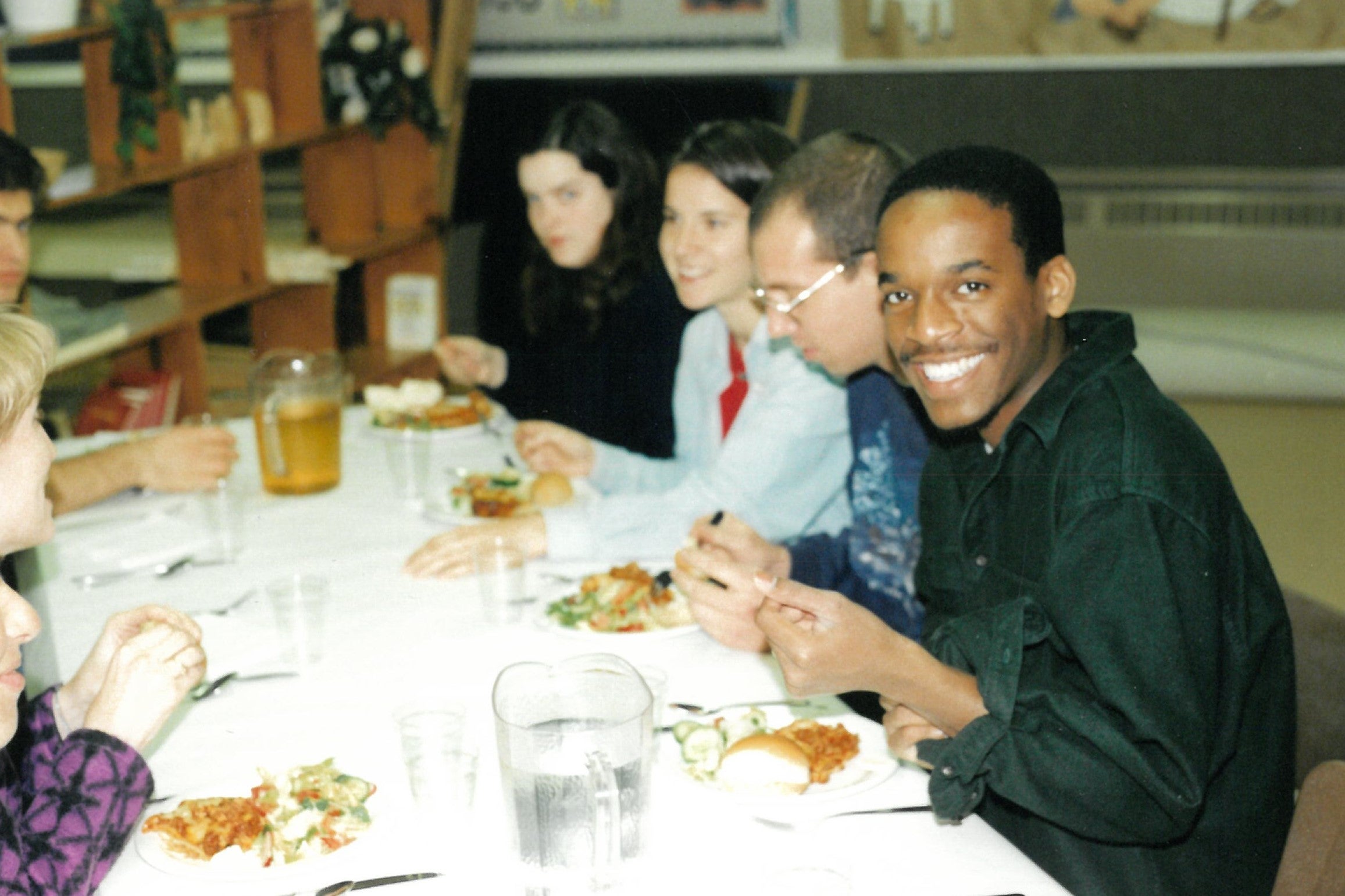 Four students sitting at table and eating together