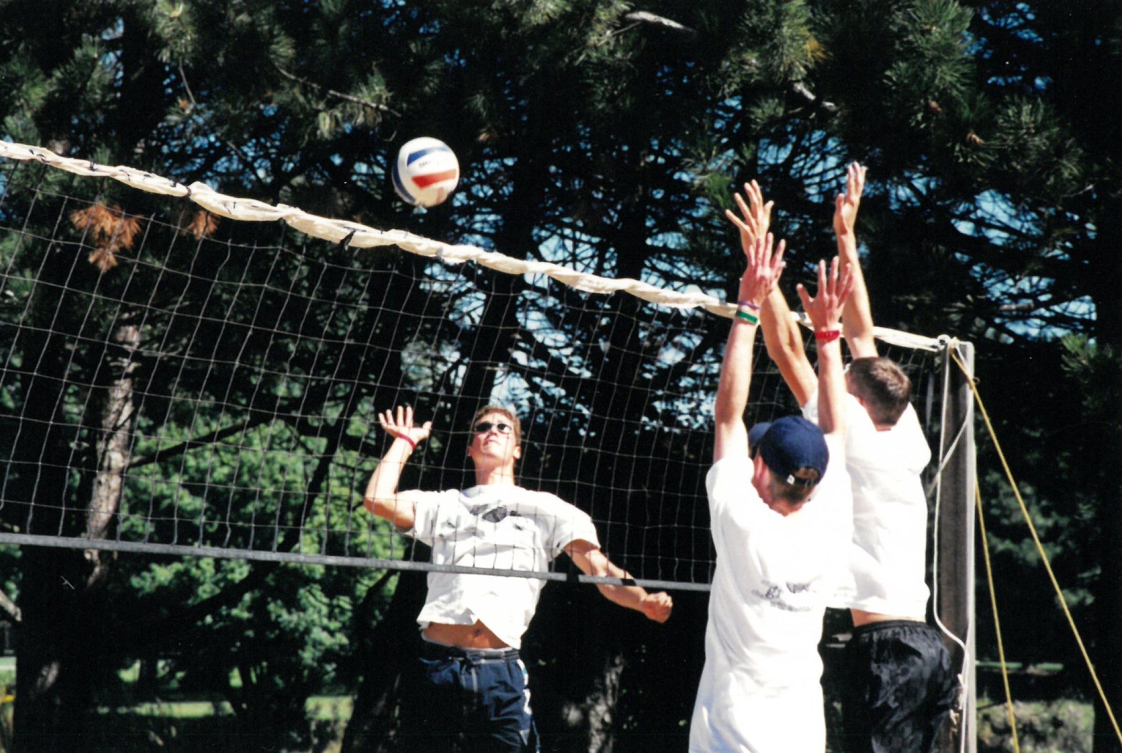 Three students playing volleyball