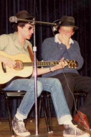 Two students play guitar on stage (80s)