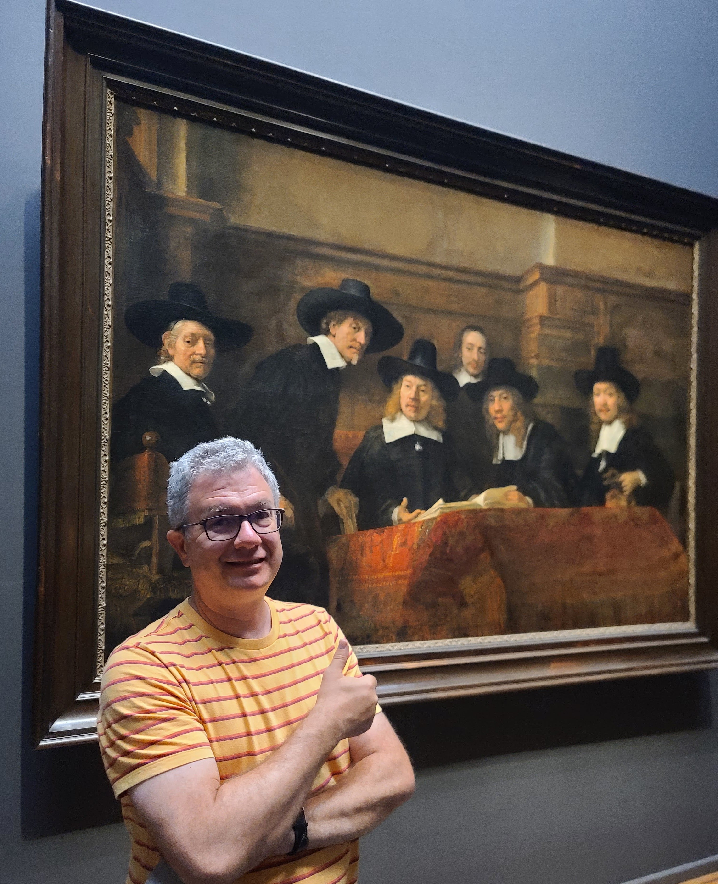 Professor Troy Osborne stands in front of a Remberandt painting 