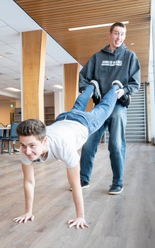 jared holding kyle's legs in a wheelbarrow pose 