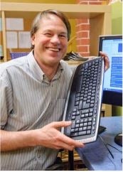 Portrait of Martin holding up a computer keyboard 