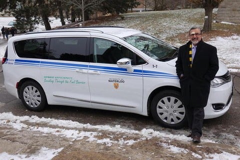 President Feridun Hamdullahpur stands next to the Central Stores hybrid service vehicle.