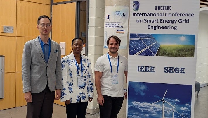 conference attendees posing before a flyer