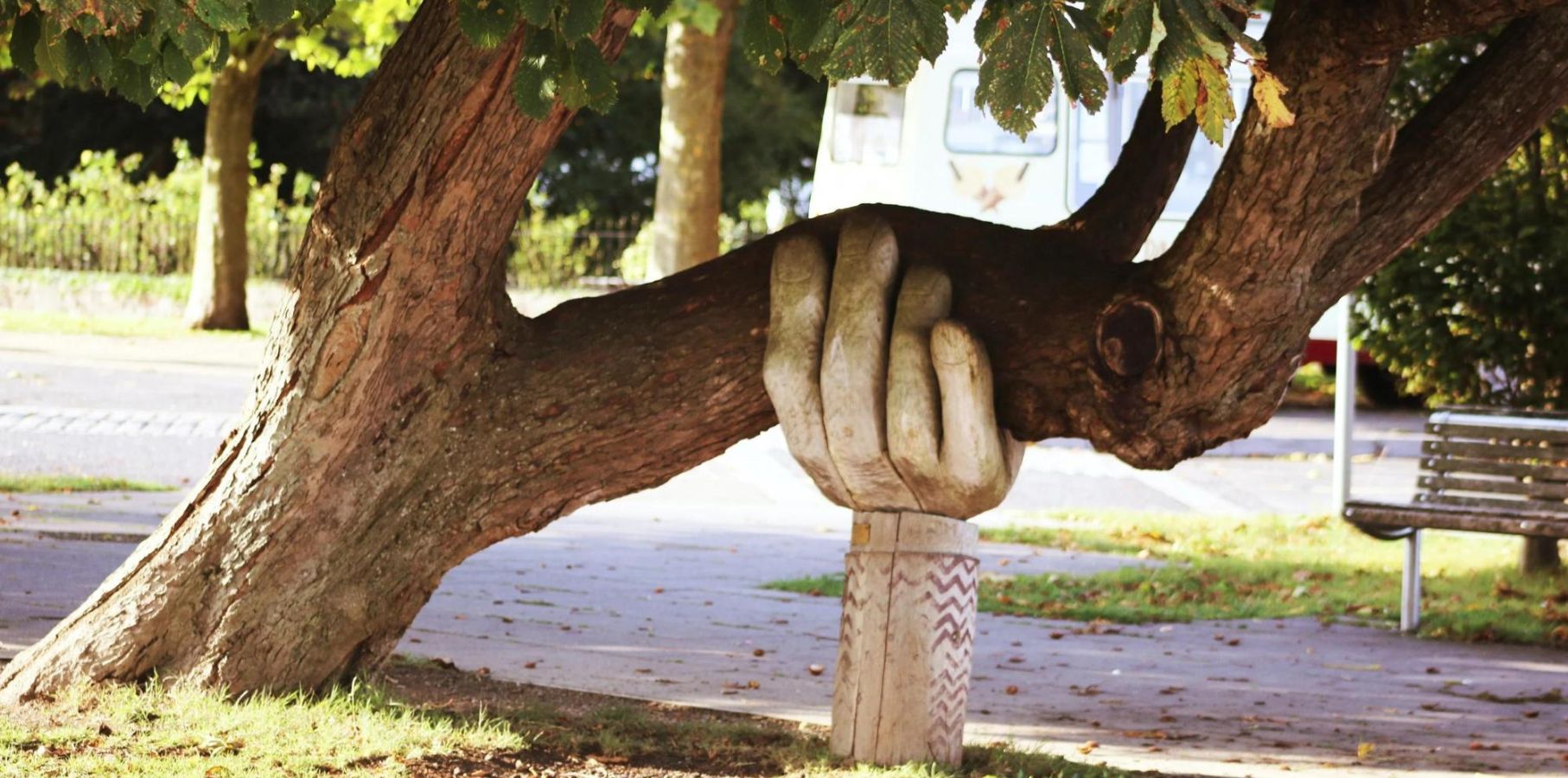 Sculpture of a large hand holding up a large tree limb