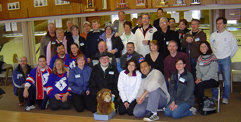 Group photo of bonspiel curlers with stuffed lion.