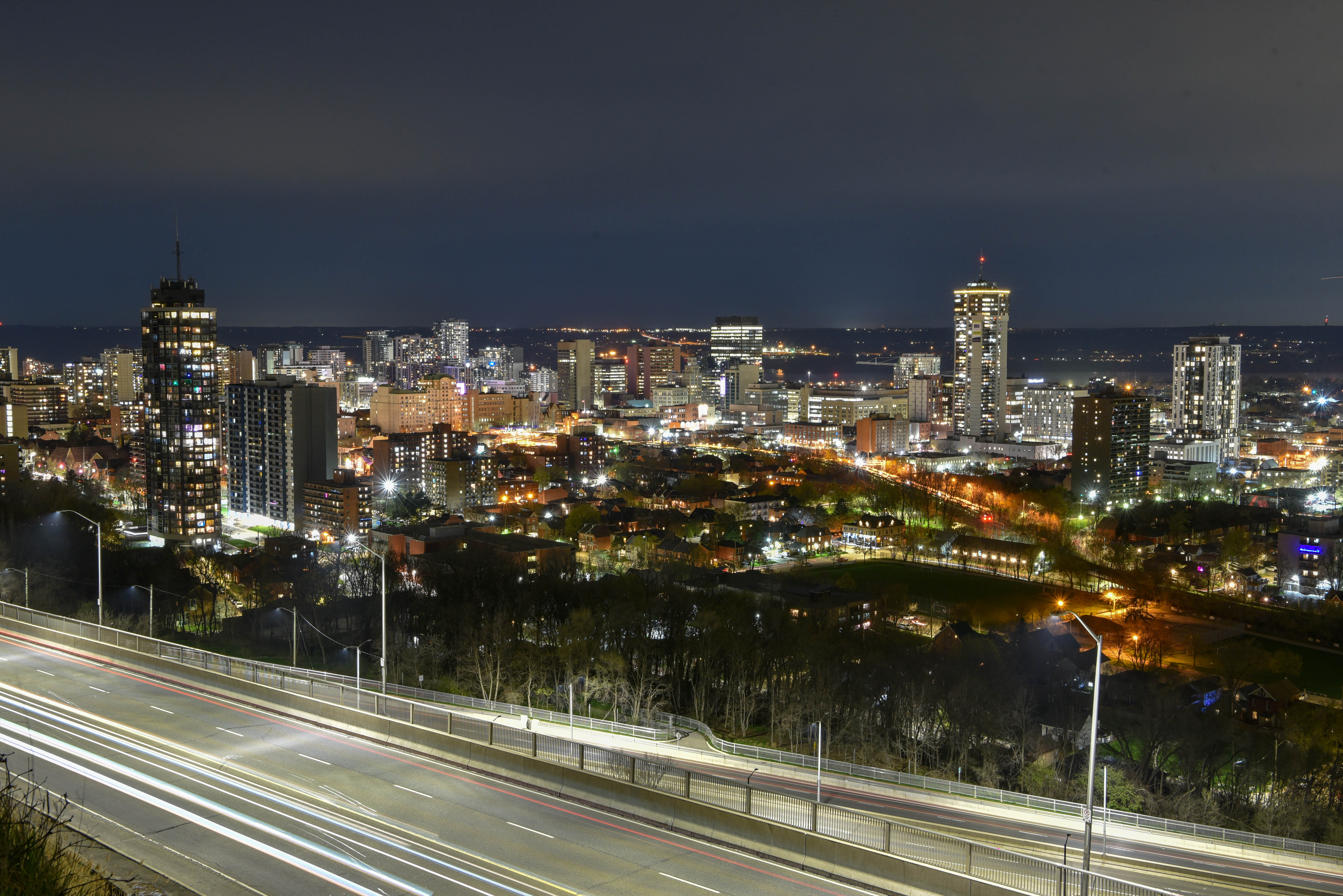 Hamilton skyline at night from mountain, buildings giving off glow of many orange and white lights