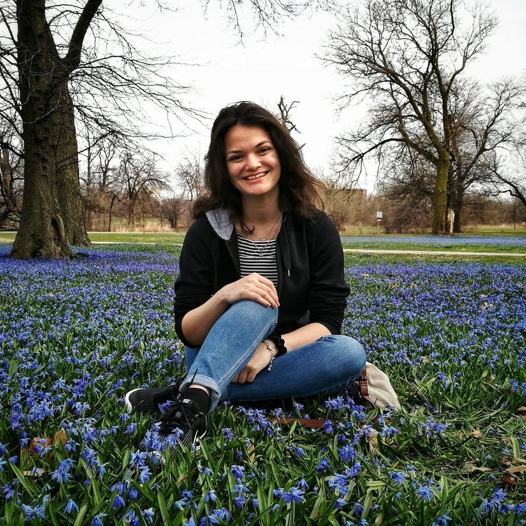 Nicole Dillen sitting in a field of flowers