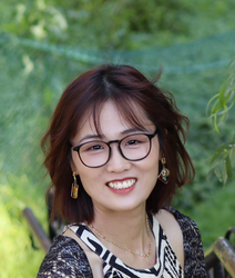 A photo of a woman with short hair and glasses smiling.