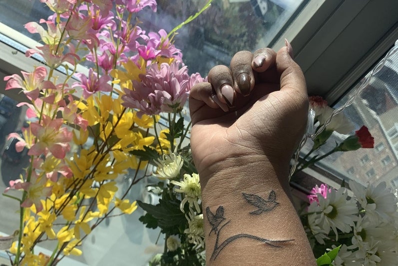 Wrist tattoo of birds carrying a branch