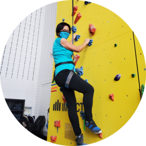 Dean Lili Liu trying out the new rock climbing wall on campus.