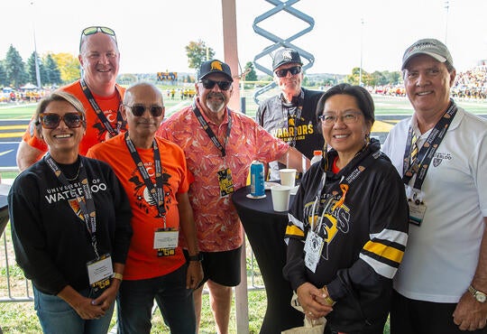 Kinesiology alumni with university president and dean at football game alumni VIP tent