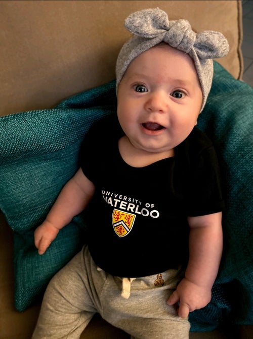 Smiling baby wearing UWaterloo shirt.