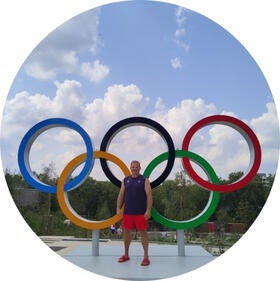 Schad Richea standing infront of the Olympic Rings.