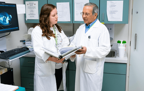Co-op student and her supervisor review patient data at cancer centre.