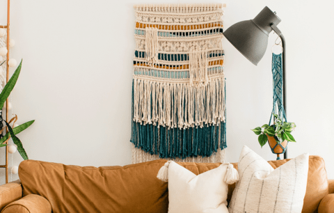 Multicoloured macrame wall hanging with layers of fringes.